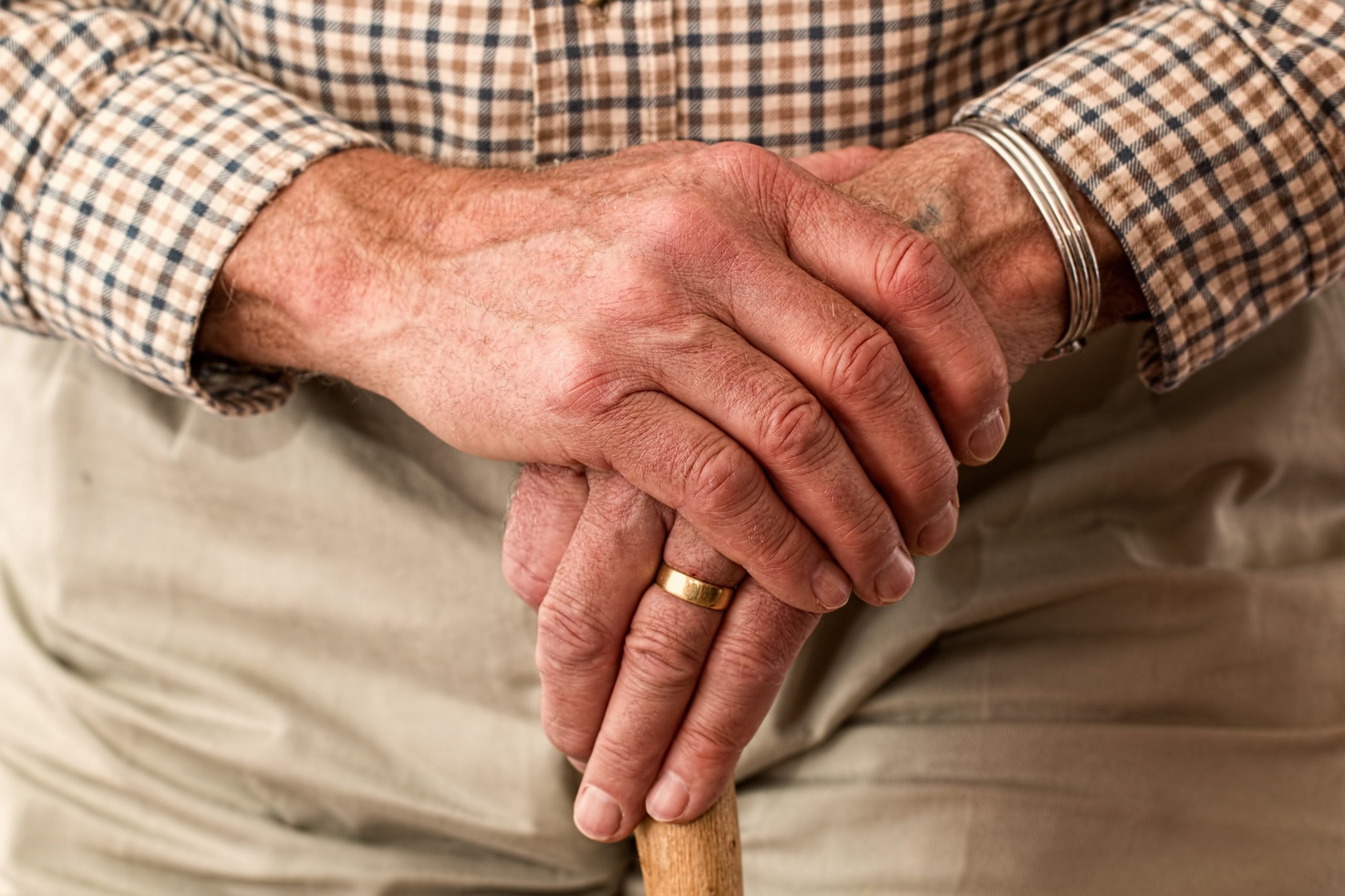 hands walking stick elderly old person min scaled